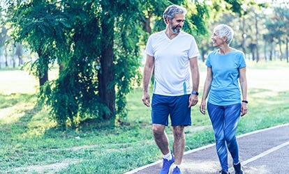 Couple actif et mature se promenant dans le parc.