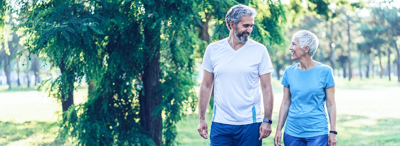 Couple actif et mature se promenant dans le parc.
