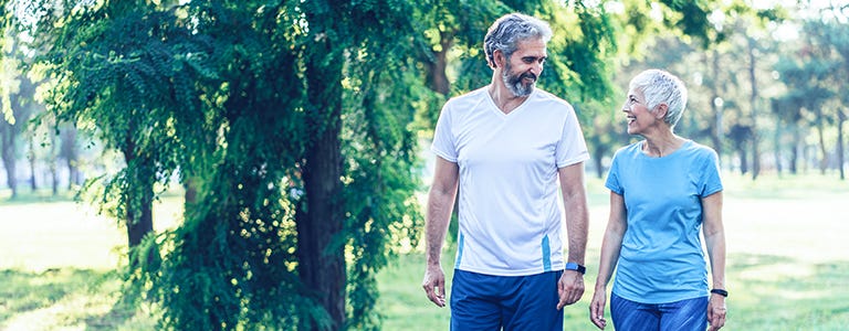 Couple actif et mature se promenant dans le parc.